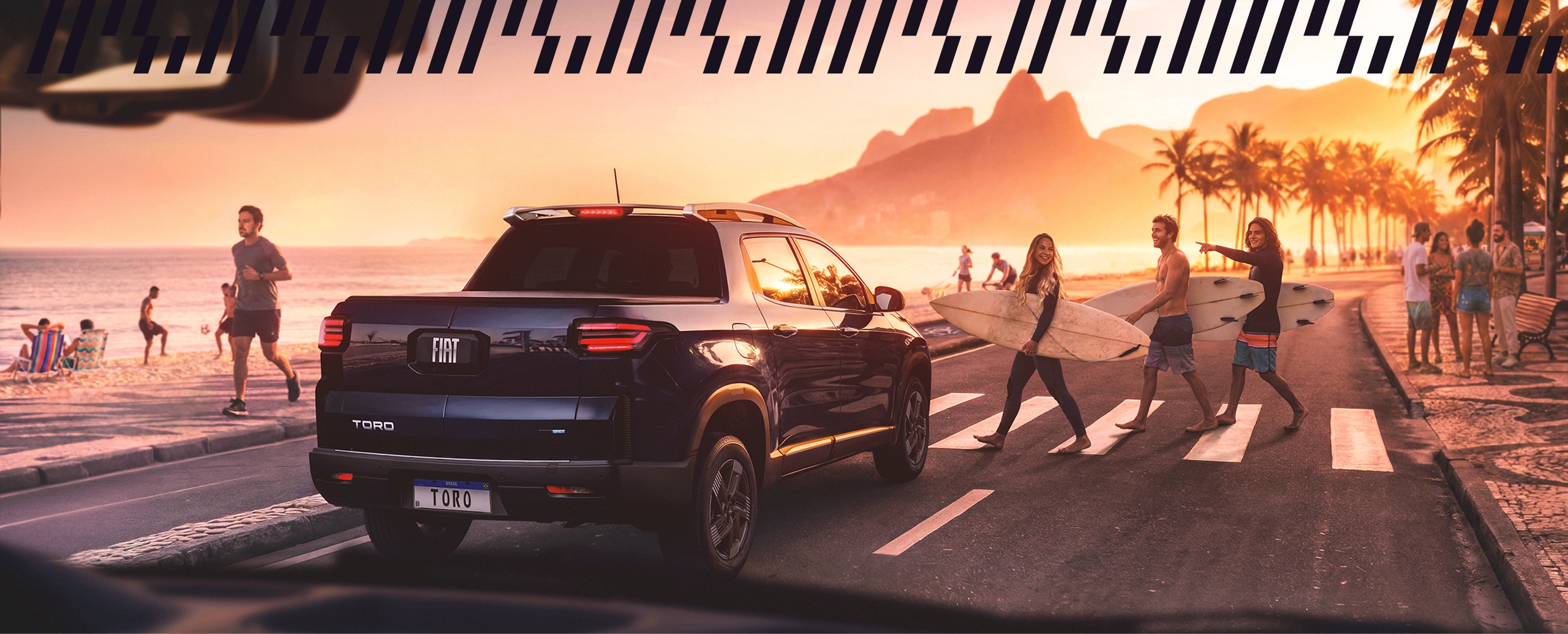 Fiat preto atravessando faixa de pedestres ao entardecer, com pessoas ao fundo sob a luz do pôr do sol no Rio de Janeiro. Fiat preto em cenário ao pôr do sol