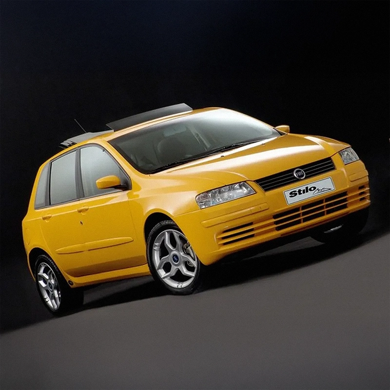 Visão frontal do Fiat Stilo na cor amarela fotografado com destaque para o design esportivo do veículo. Visão frontal do Fiat Stilo na cor amarela fotografado com destaque para o design esportivo do veículo.