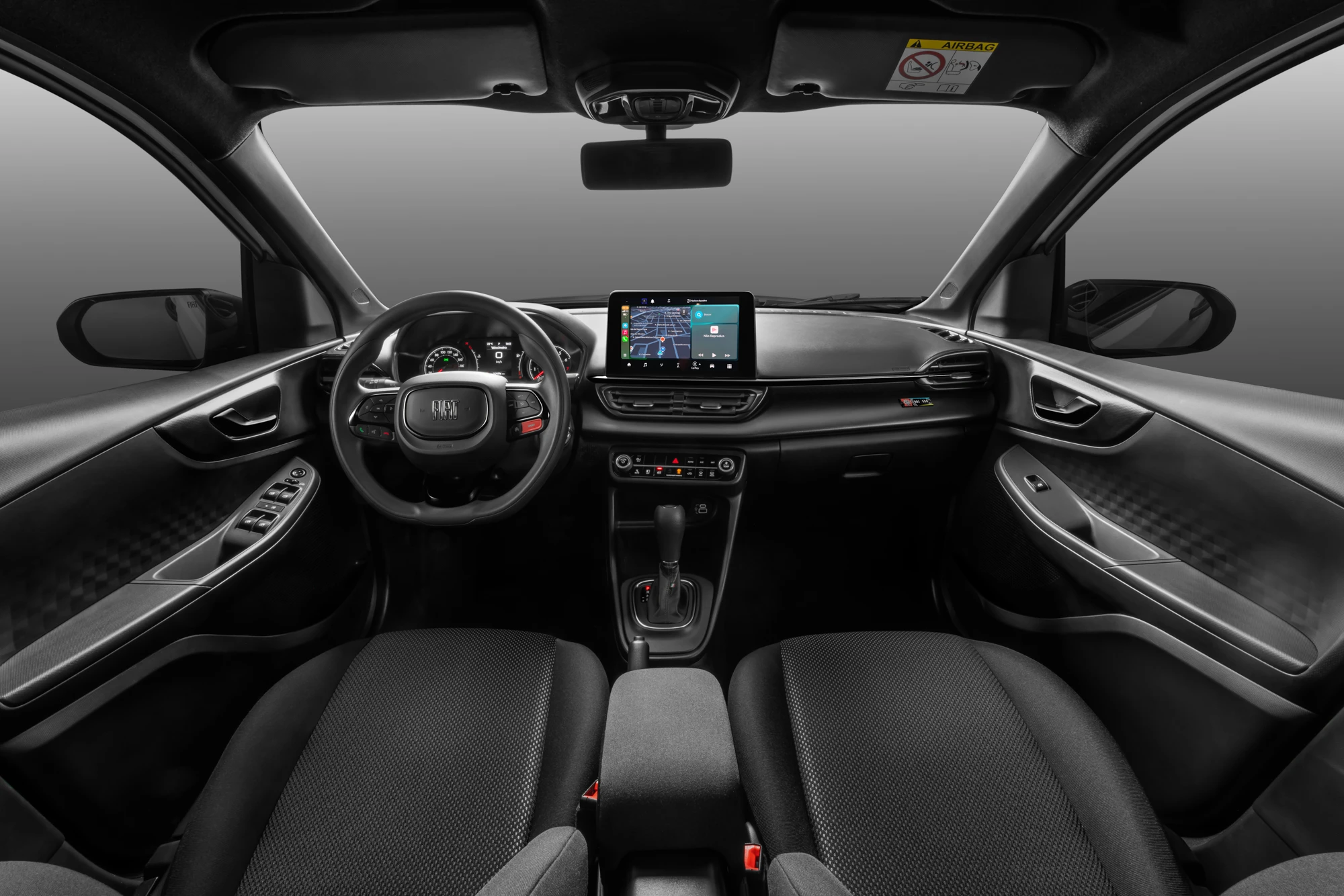Visão do painel e cockpit no interior do Fiat Pulse Edição Especial LollaBR. Todos os detalhes são na cor preta, o volante possui diversas funcionalidades, bem como a Central Multimídia no centro do painel.